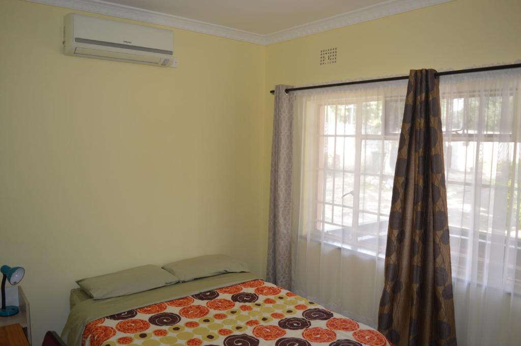 a bedroom with a bed and a window at Kasuda House - Rent the entire house in Lusaka