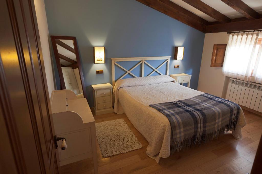 - une chambre dotée d'un lit avec un mur bleu dans l'établissement La Quintana de Somao, Casa de Arriba, à Pravia