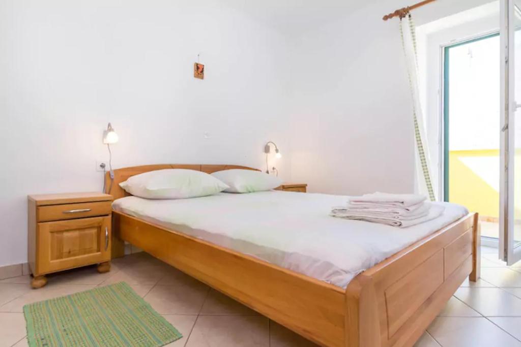 a bedroom with a bed with a night stand and a window at Casa Limone in Belej