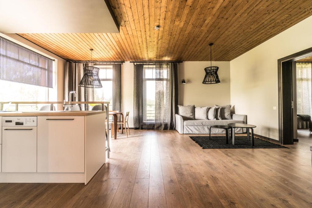 una cucina e un soggiorno con soffitto in legno di Prieka pietura (on Šveices street) a Sigulda