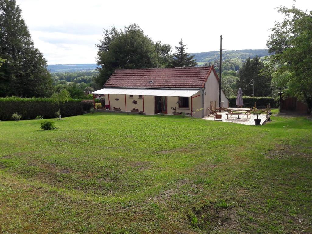 a small house with a large grassy yard at Gite Le Savart in Chartèves