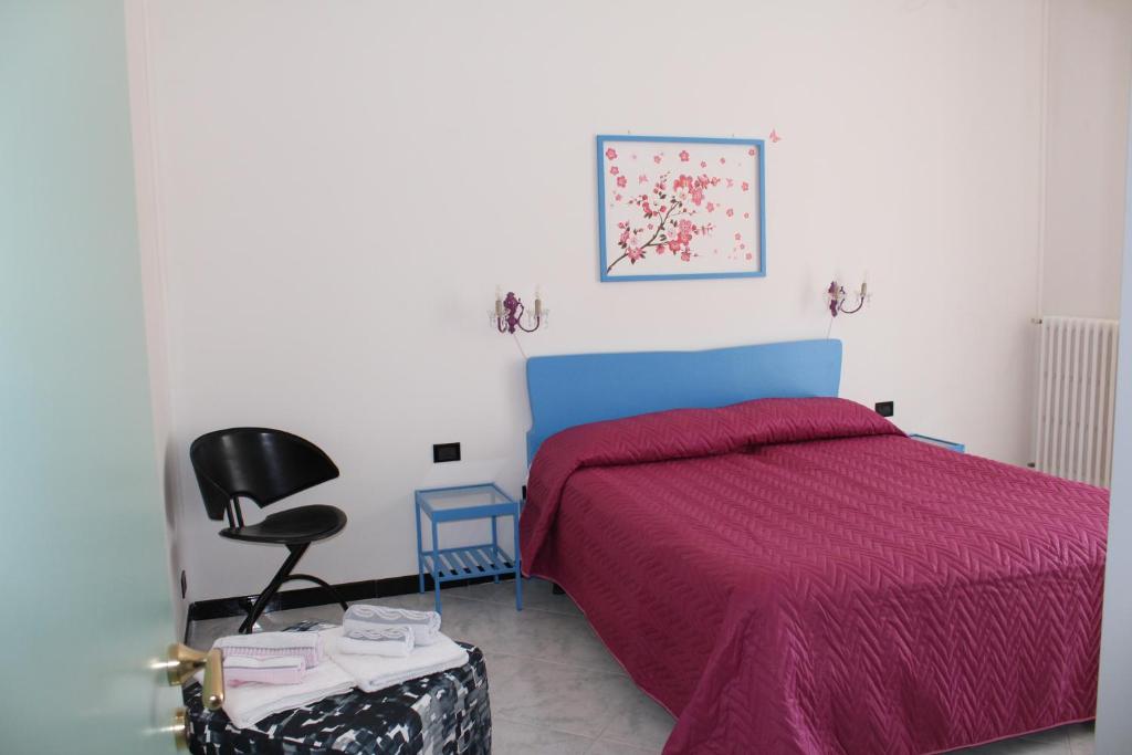 1 dormitorio con cama roja y silla negra en casa angela, en Castellana Grotte