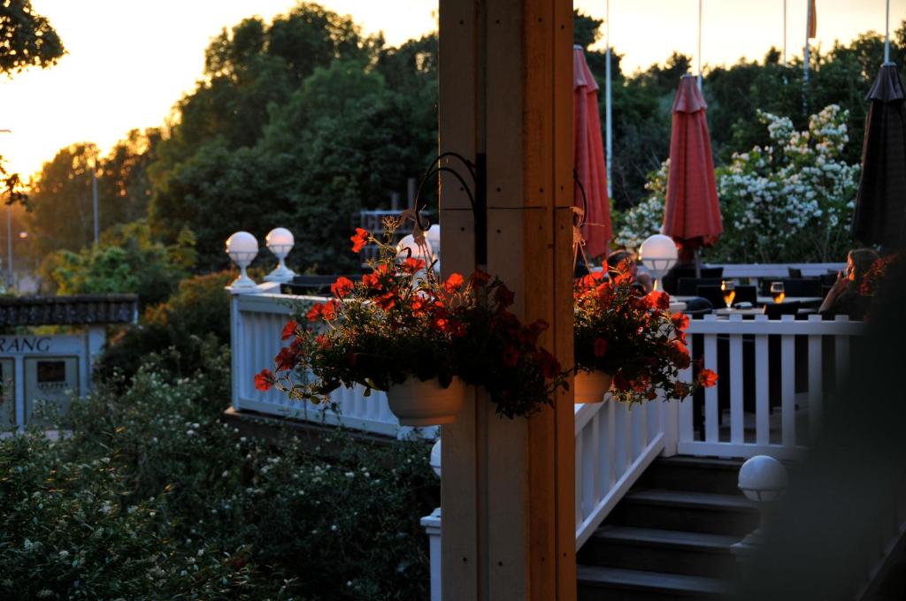 um alpendre com flores em vasos numa cerca em Eckerö Hotell & Restaurang em Eckerö