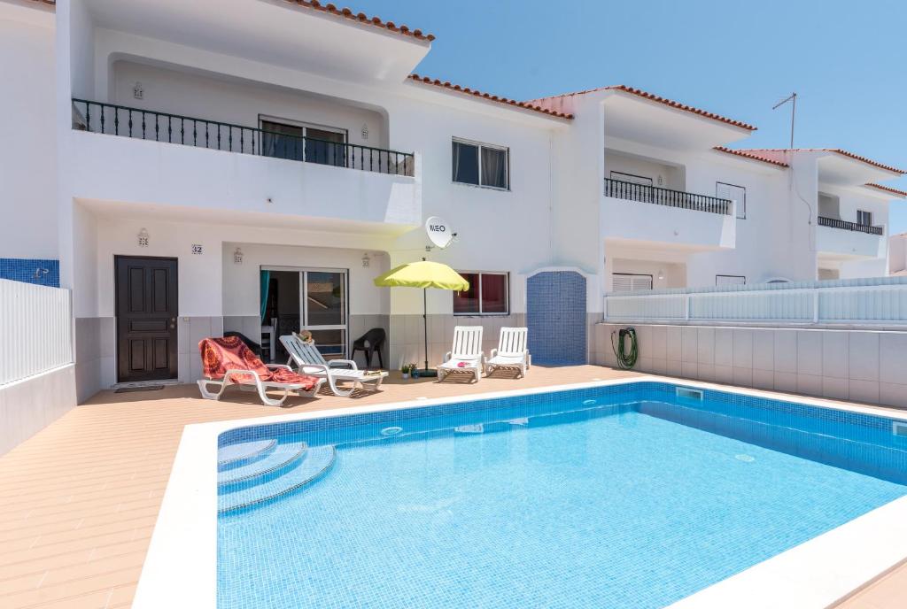 a villa with a swimming pool in front of a house at Villa Mar with private pool in Albufeira