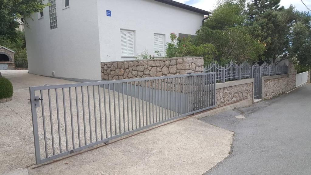 a metal fence in front of a house at Apartman Zahira in Karlobag