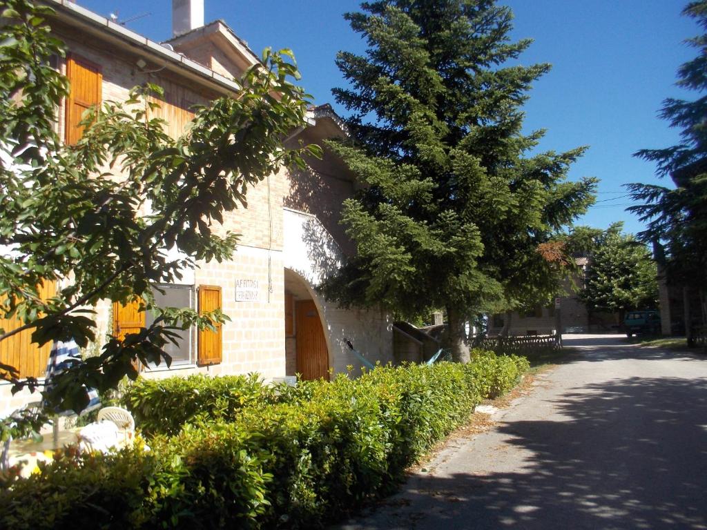 um edifício com uma árvore ao lado de uma rua em villino in montagna em Montemonaco