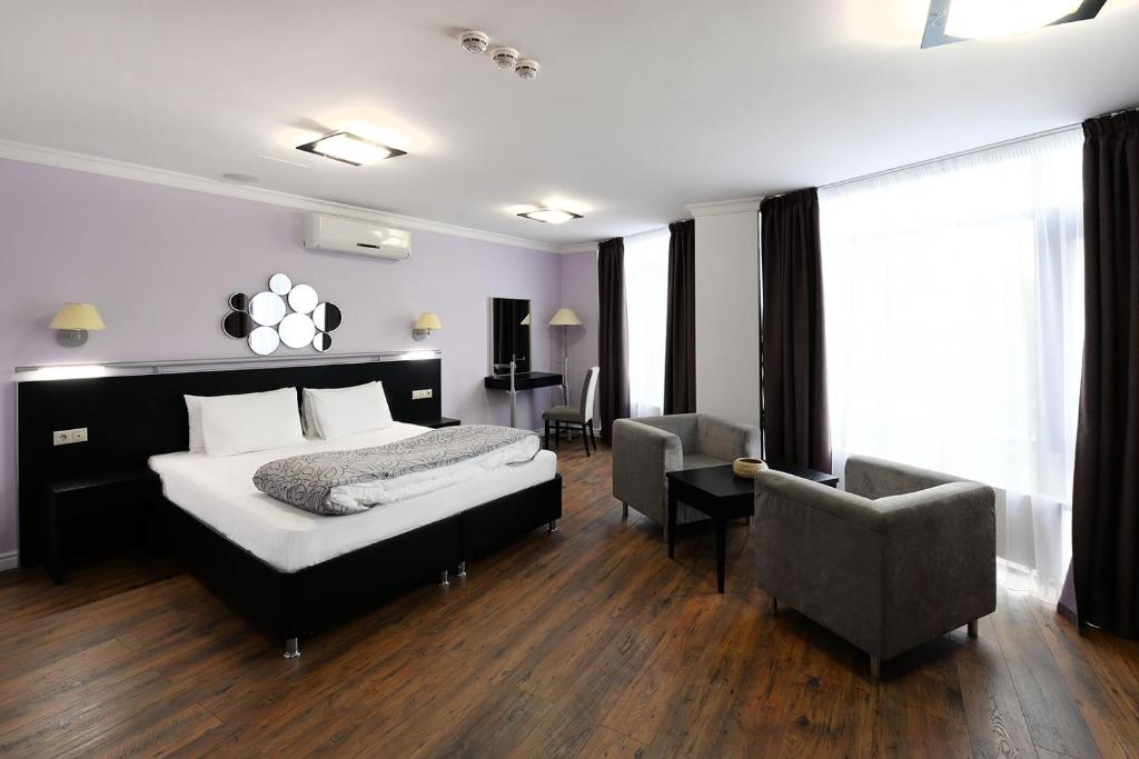 a bedroom with a bed and a desk and a chair at Business Hotel Vremena Goda in Moscow