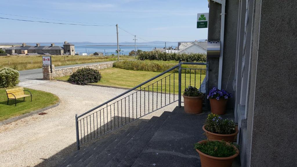 un escalier avec des plantes en pot sur le côté du bâtiment dans l'établissement Leim Siar Bed And Breakfast, à Belmullet