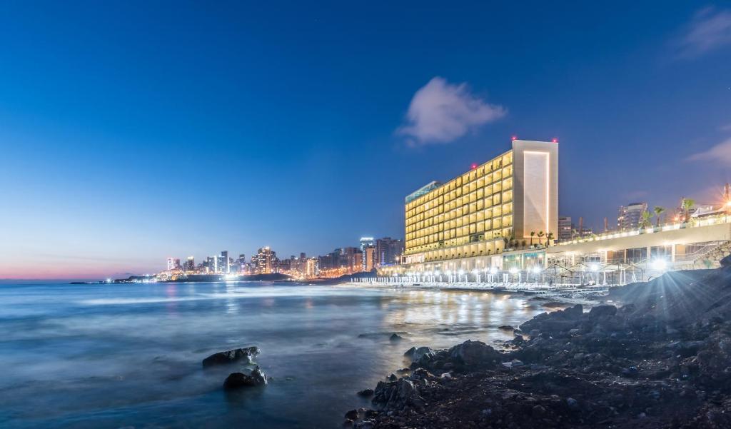een hotel op het strand 's nachts met de oceaan bij Lancaster Eden Bay in Beiroet