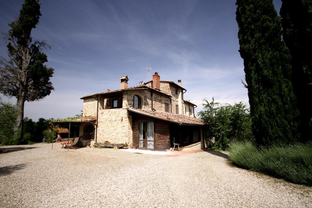 una vieja casa de piedra sentada en la parte superior de una entrada en Agriturismo Molinuzzo, en Barberino di Val d'Elsa