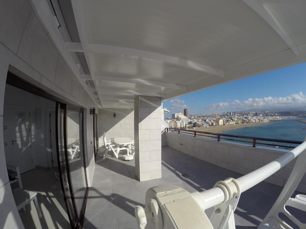 uma varanda de um edifício com vista para o oceano em Apartamentos Juan Pérez- Viviendas Vacacionales em Las Palmas de Gran Canaria