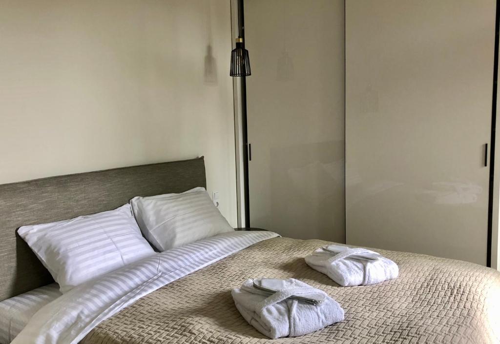 two towels sitting on top of a bed at Memel home old city apartment in Klaipėda
