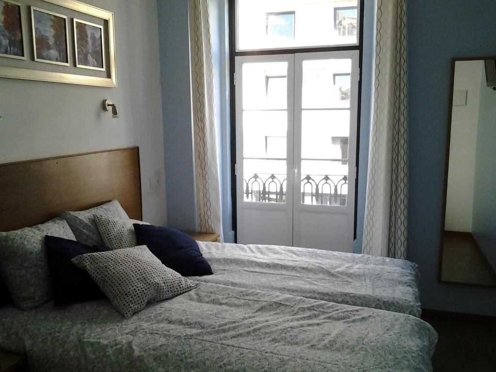 a bedroom with a bed with a large window at Baixainn in Lisbon