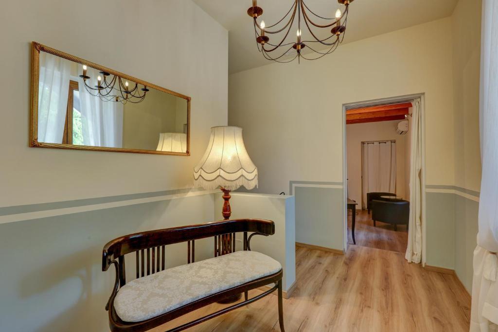 a chair in a room with a mirror and a lamp at B&B La Contessa in Monfalcone