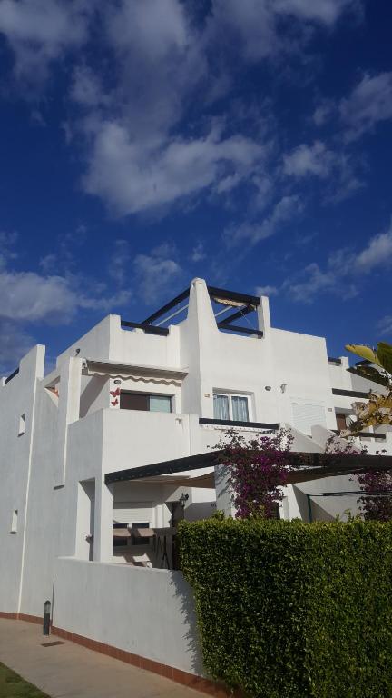 um grande edifício branco com uma sebe à sua frente em Jardin 566 em Alhama de Múrcia