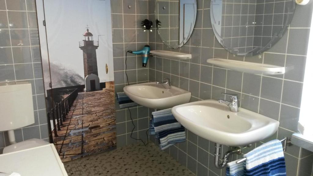 a bathroom with two sinks and a lighthouse on the wall at Reiterhof Jägersburg Ferienwohnung in Varel