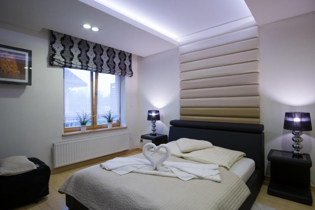 a bedroom with a bed with two towels on it at Aqua Park Residence in Zakopane