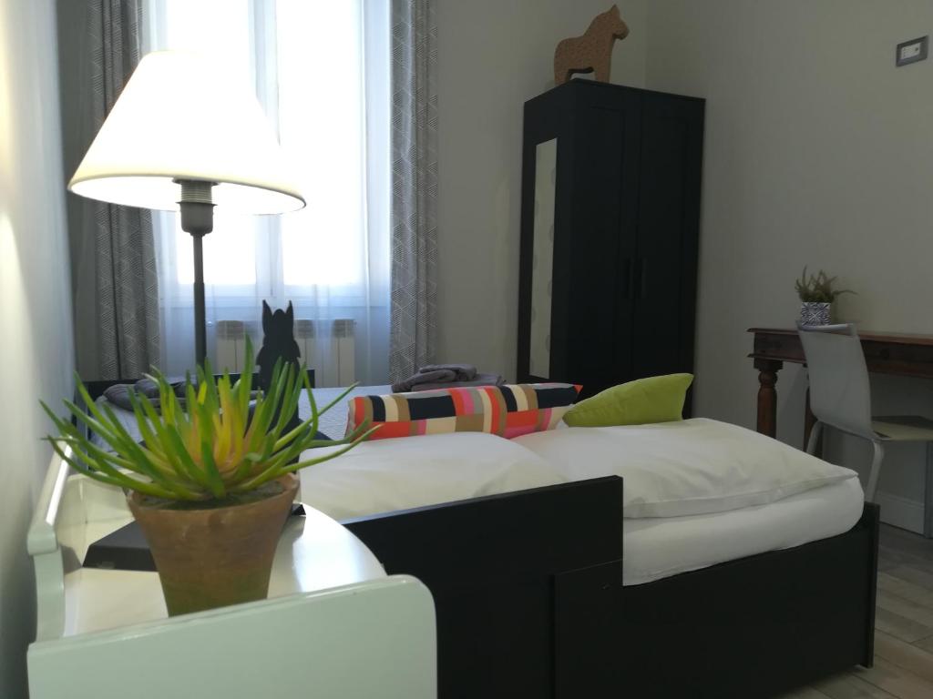 1 dormitorio con cama y mesa con maceta en Le Volute al Pigneto, en Roma