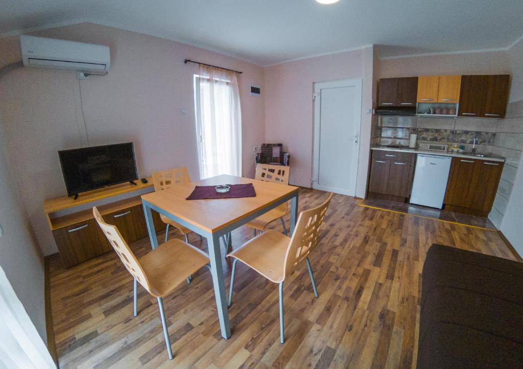cocina y comedor con mesa y sillas en Apartmani "STEFANOVIĆ", en Soko Banja