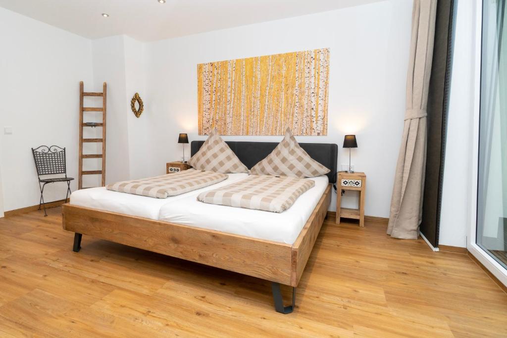 a bedroom with a large bed with a wooden floor at Old Town Apartments in Kaufbeuren