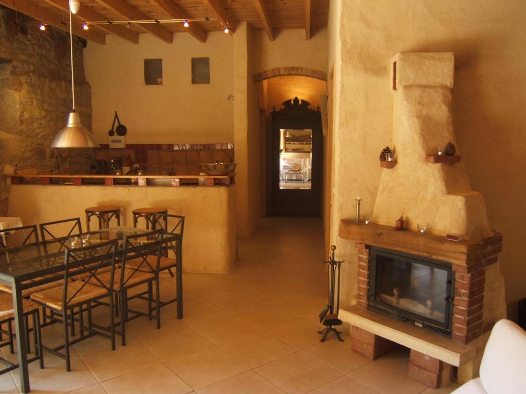 a living room with a fireplace and a table and chairs at Gite la Tour in Pépieux