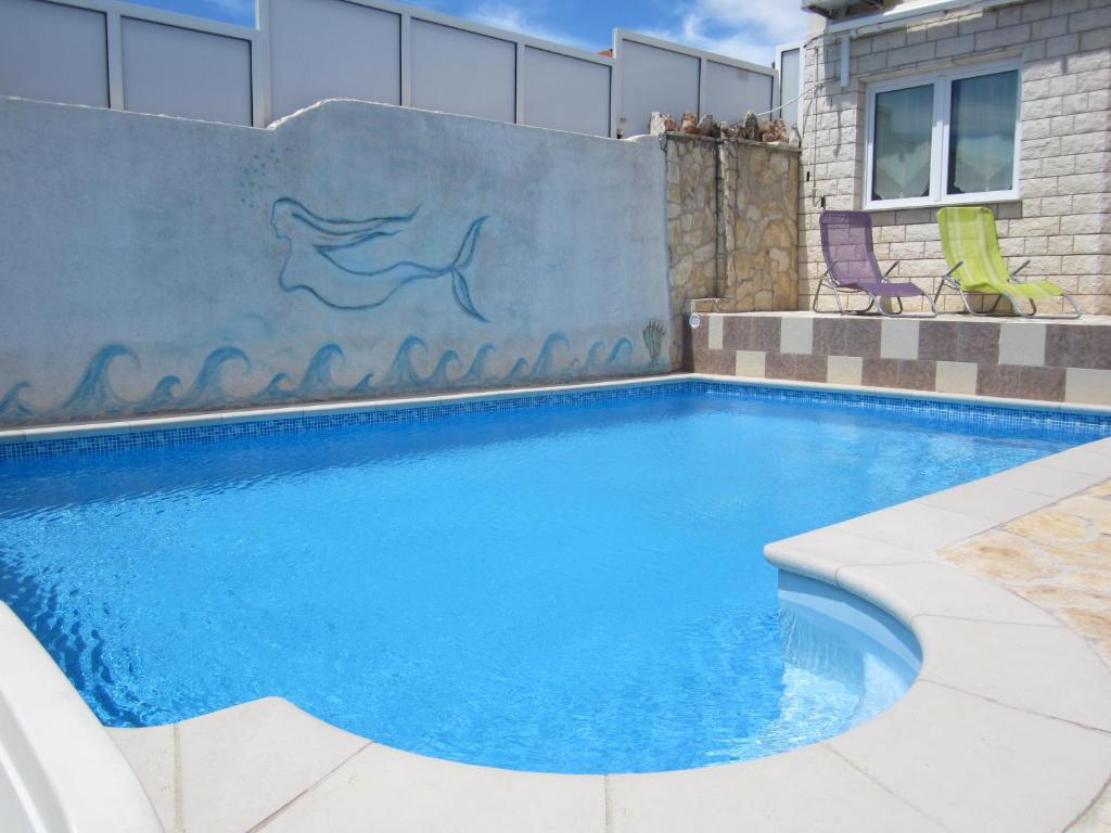 basen z niebieską wodą przed ścianą w obiekcie Apartments Villa Bella Vista Hvar w Hvarze