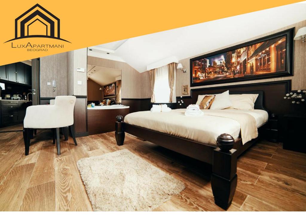 ein Schlafzimmer mit einem großen Bett und einem weißen Stuhl in der Unterkunft Lux apartmani Beograd in Belgrad
