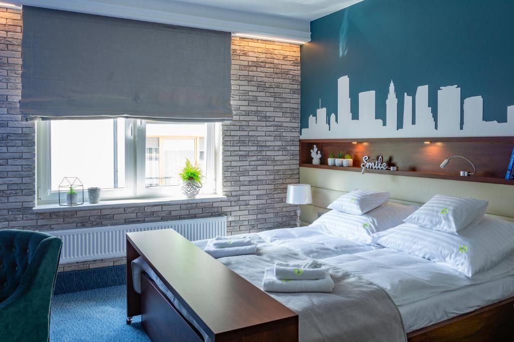 a bedroom with a large bed and a desk and a window at AGA Tenis Apartments by Radwańska in Krakow