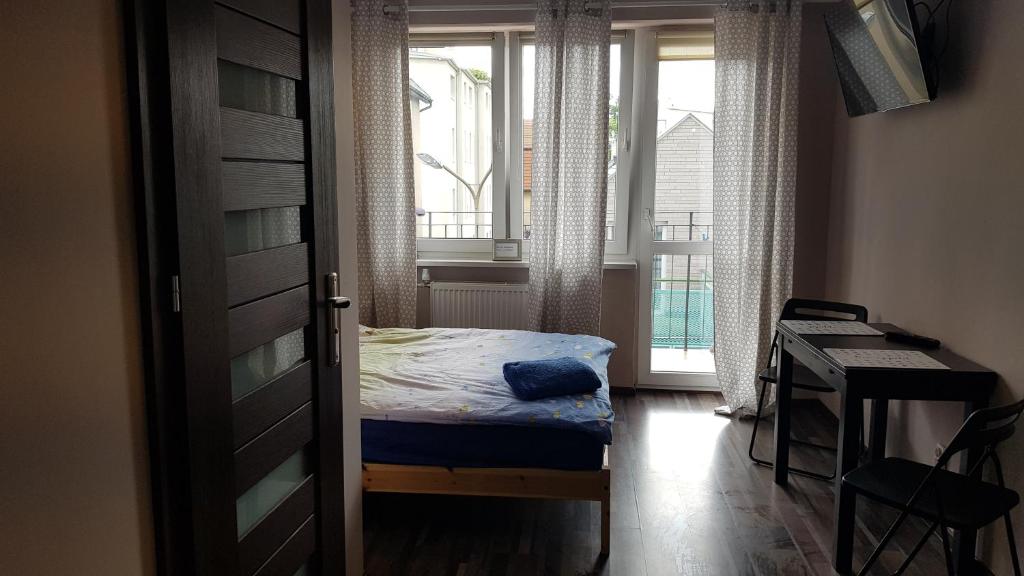 1 dormitorio con cama, escritorio y ventana en StudioSpanie Sopot beach rooms, en Sopot