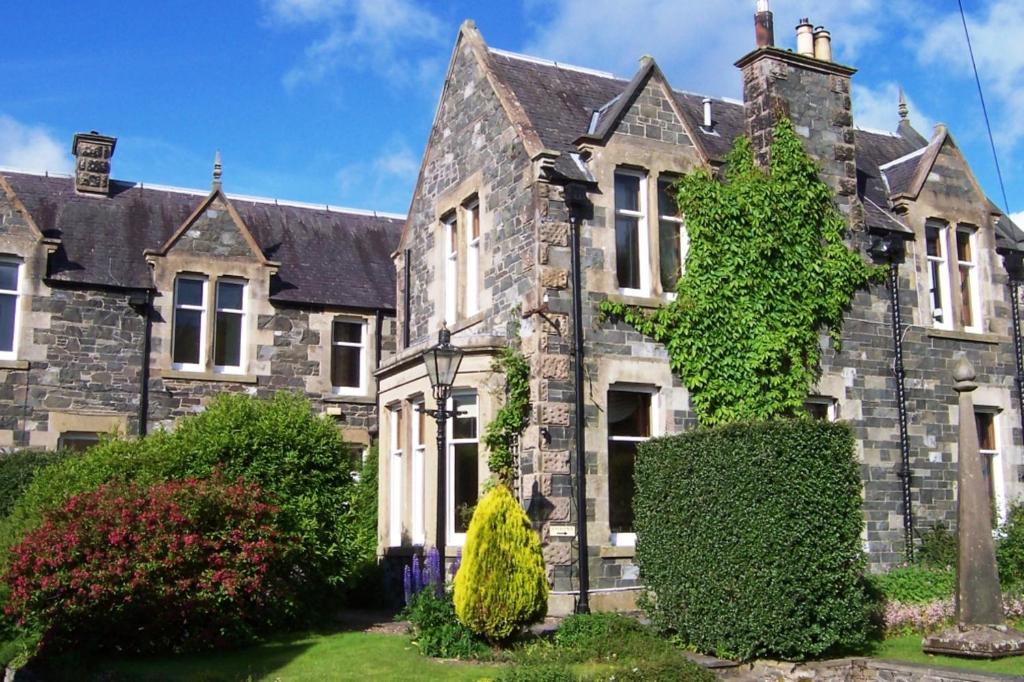 an old stone house with ivy at Caddon View Country Guest House in Innerleithen