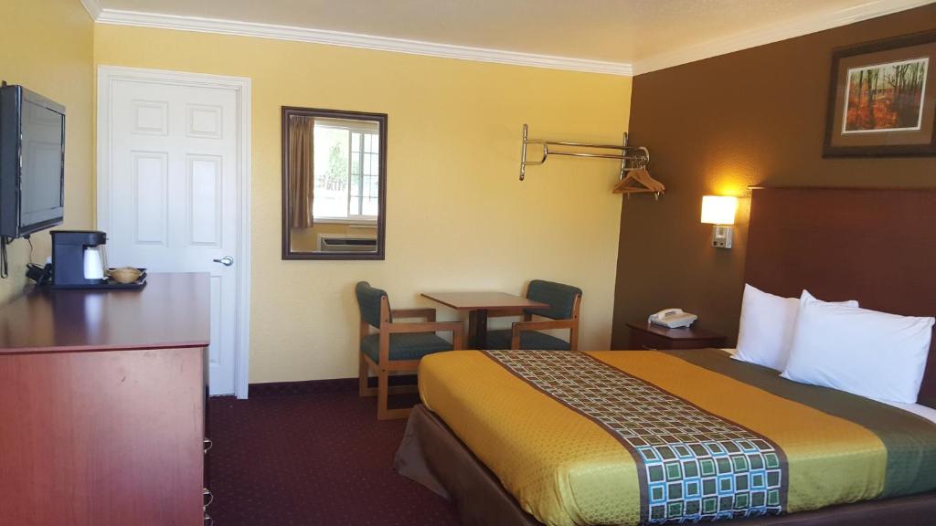 a hotel room with a bed and a desk and a table at Interstate 8 Motel in Lakeview