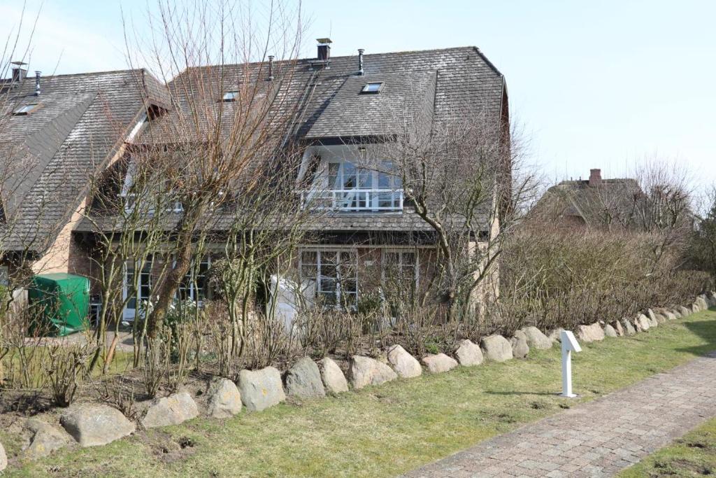 a house with a stone fence in front of it at Krause in Munkmarsch