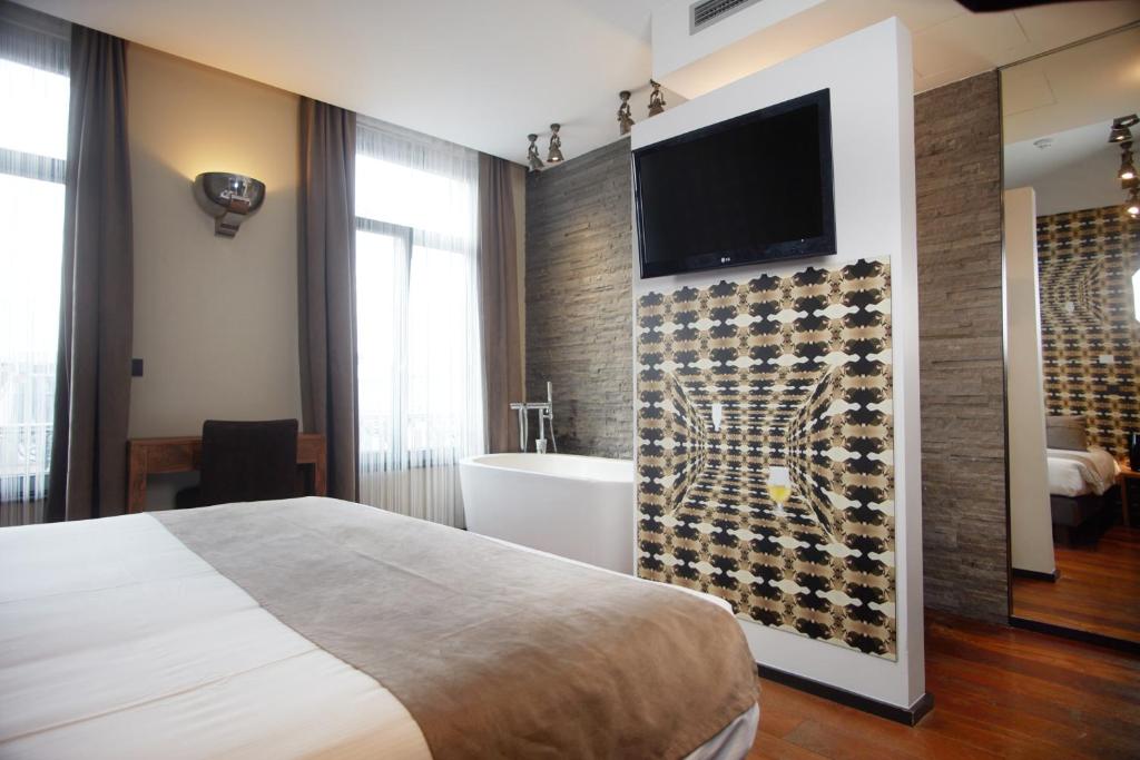 a bedroom with a white bed and white walls at Boutique Hotel Saint-Géry in Brussels