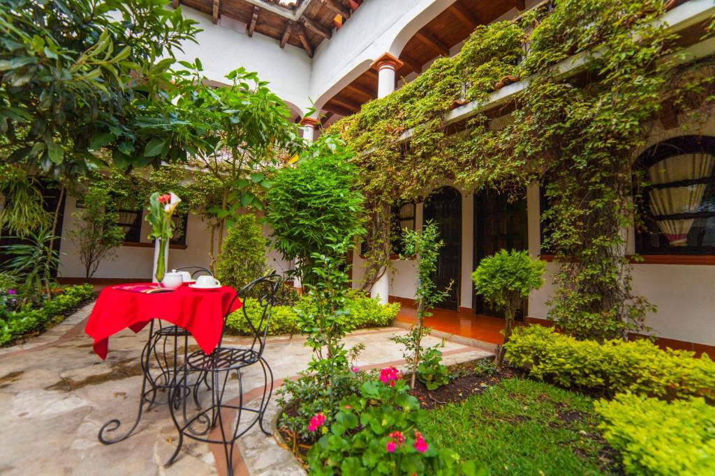 een tafel op de binnenplaats van een gebouw met planten bij Hotel Jovel - Pago solo en efectivo in San Cristóbal de Las Casas