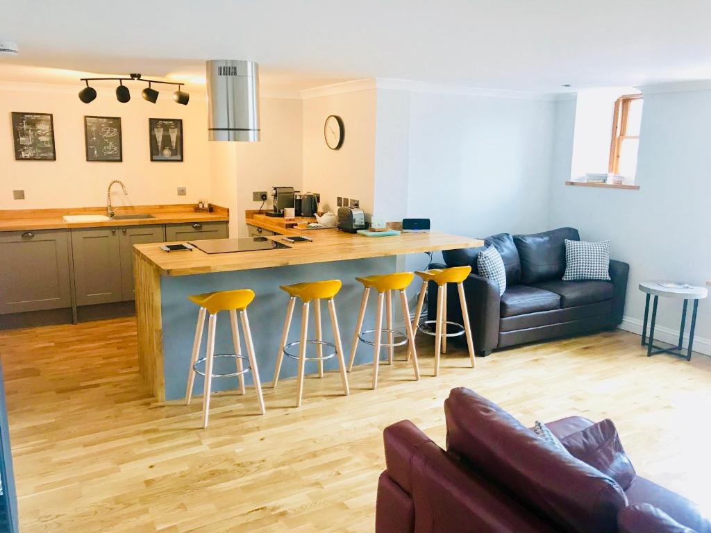 a kitchen and living room with a couch and a bar at Apartment 42a by the River in Inverness