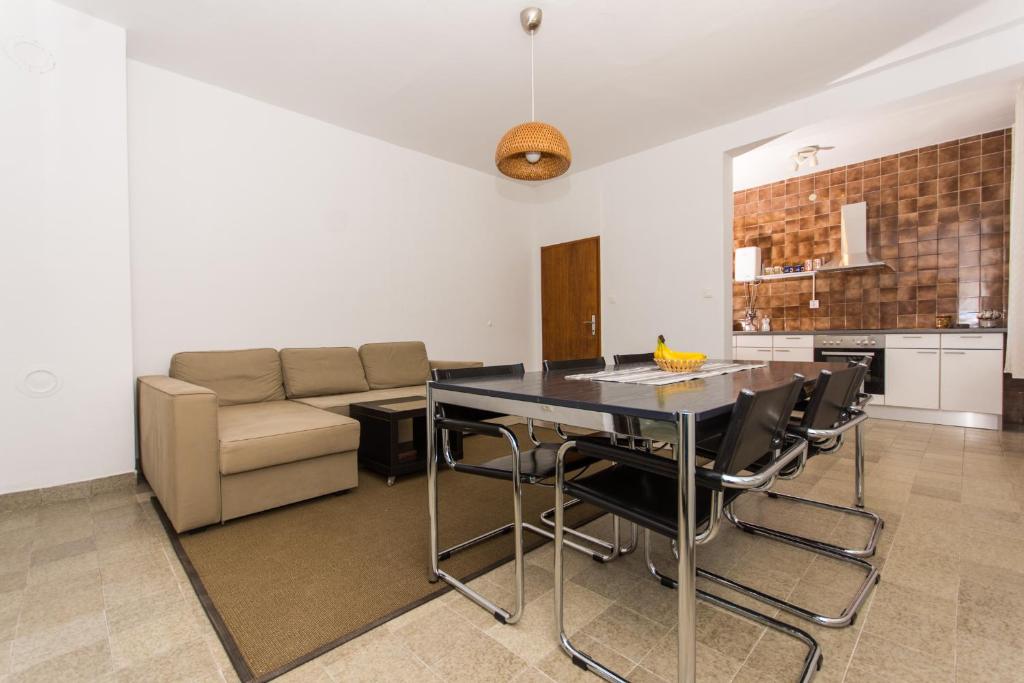 uma sala de estar com uma mesa e um sofá em Apartman Maja em Trogir