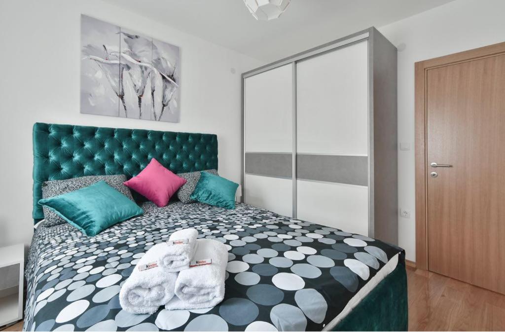 a bedroom with a large bed with colorful pillows at Lux Apartman Daria in Zlatibor