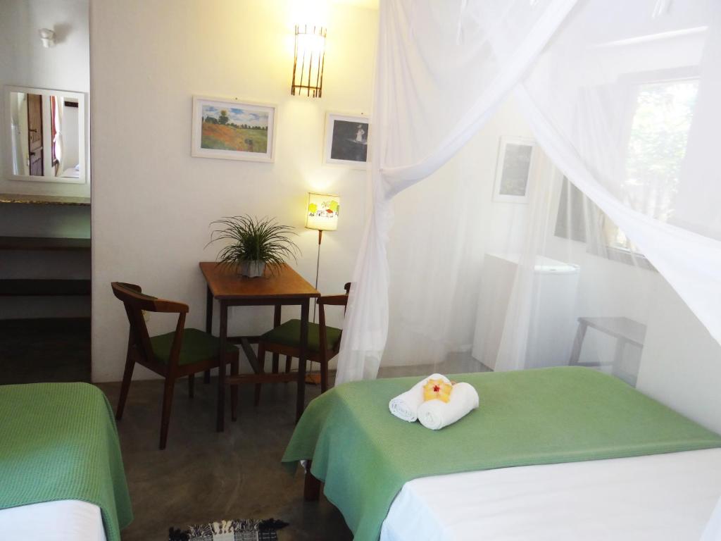 a hotel room with two beds with a towel on the bed at Canto do Sabiá Caraíva in Caraíva