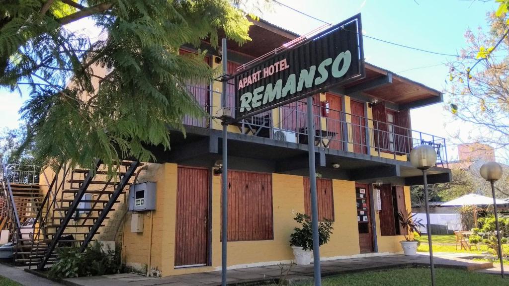 un edificio con una señal delante de él en Remanso Apart Hotel, en Termas del Daymán