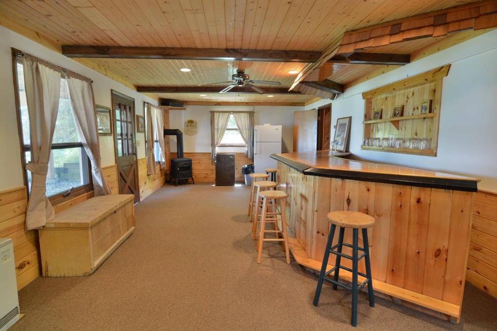 a kitchen with a bar and stools in a room at Kenny Lodge Condo in Namekagon