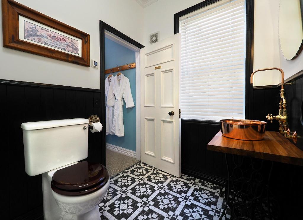 a black and white bathroom with a toilet and a sink at The Ferry Bed & Breakfast in Queenstown