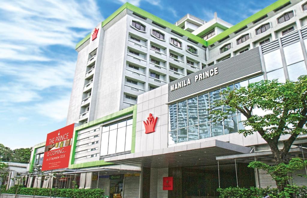 a hotel building with a red sign on it at Manila Prince Hotel in Manila