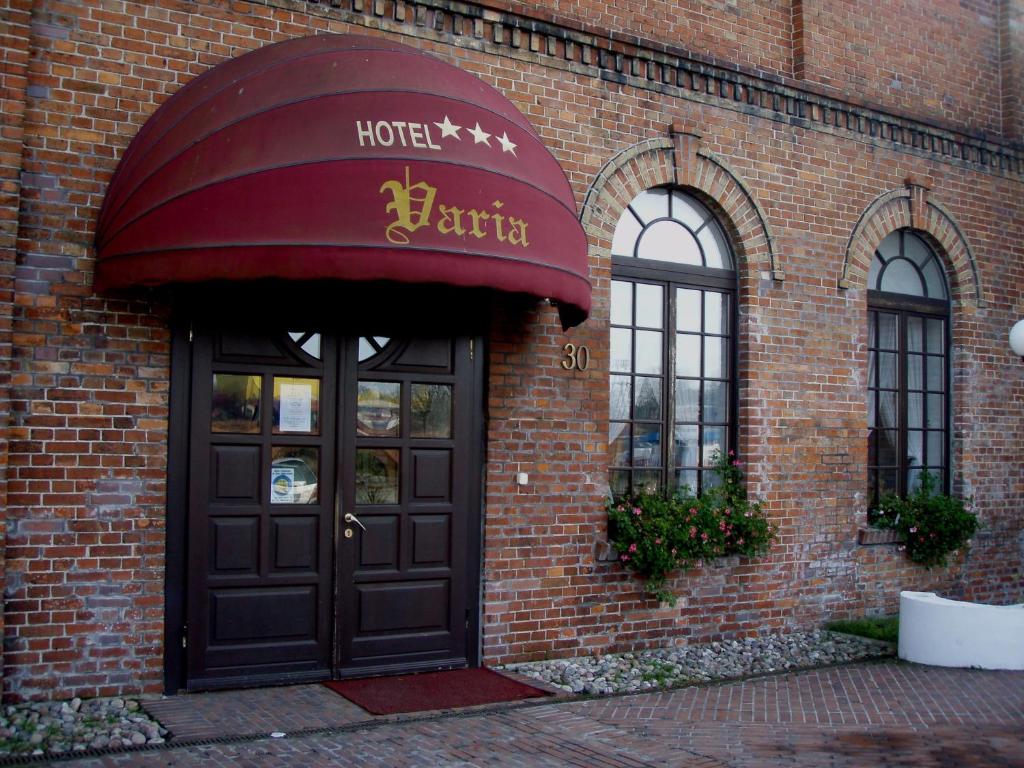 una puerta delantera de un hotel con toldo rojo en Hotel Restauracja Varia, en Działdowo