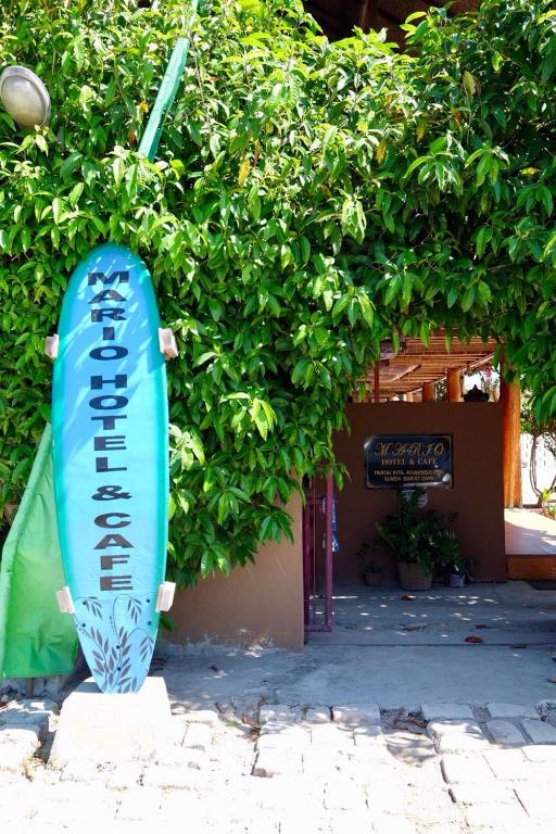 a surfboard statue sitting in front of a building at Mario Hotel and Cafe in Weetebula