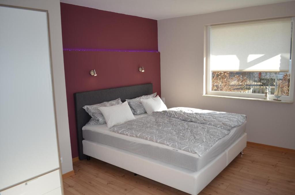 a bedroom with a bed with a purple accent wall at Jana's Fewo in Lübeck