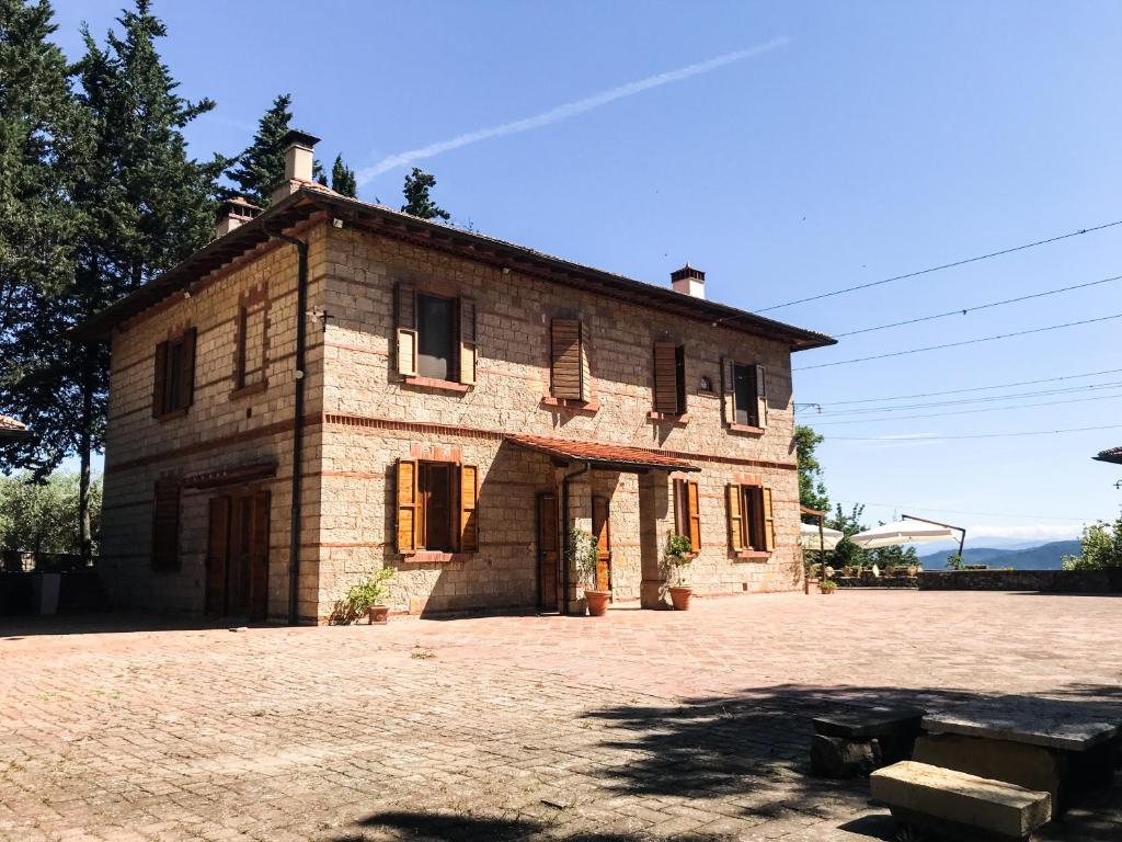 una antigua casa de piedra con un gran patio en Agriturismo Testalepre en Greve in Chianti