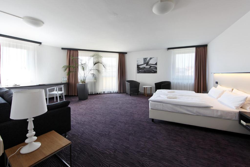 um quarto de hotel com uma cama e um sofá em Dietrich-Bonhoeffer-Hotel Berlin Mitte em Berlim