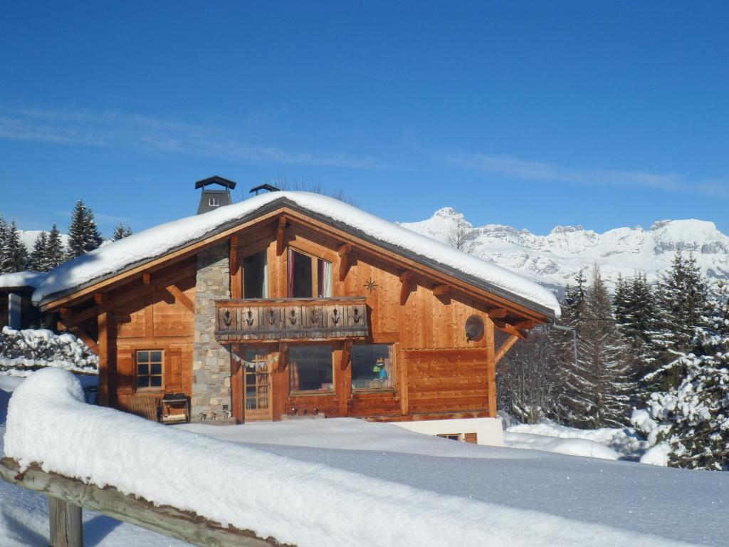 une cabane en rondins avec de la neige sur le toit dans l'établissement Marie Mont Blanc vue Mont Blanc, à Saint-Gervais-les-Bains