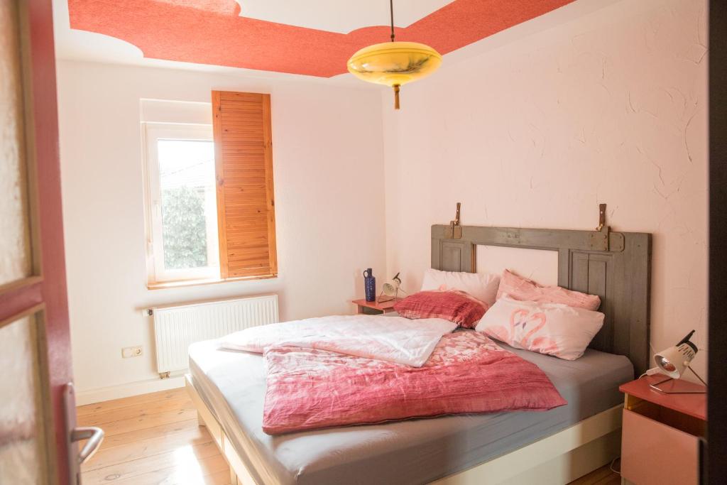 um quarto com uma cama com lençóis cor-de-rosa e brancos em Appartementhaus "Schöni" em Senftenberg