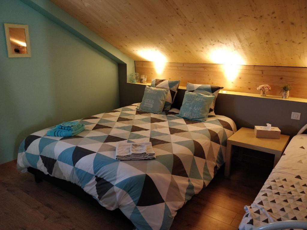 a bedroom with a large bed with a checkerboard pattern at Chambre Chaleureuse chez l'habitant in Bourg-en-Bresse